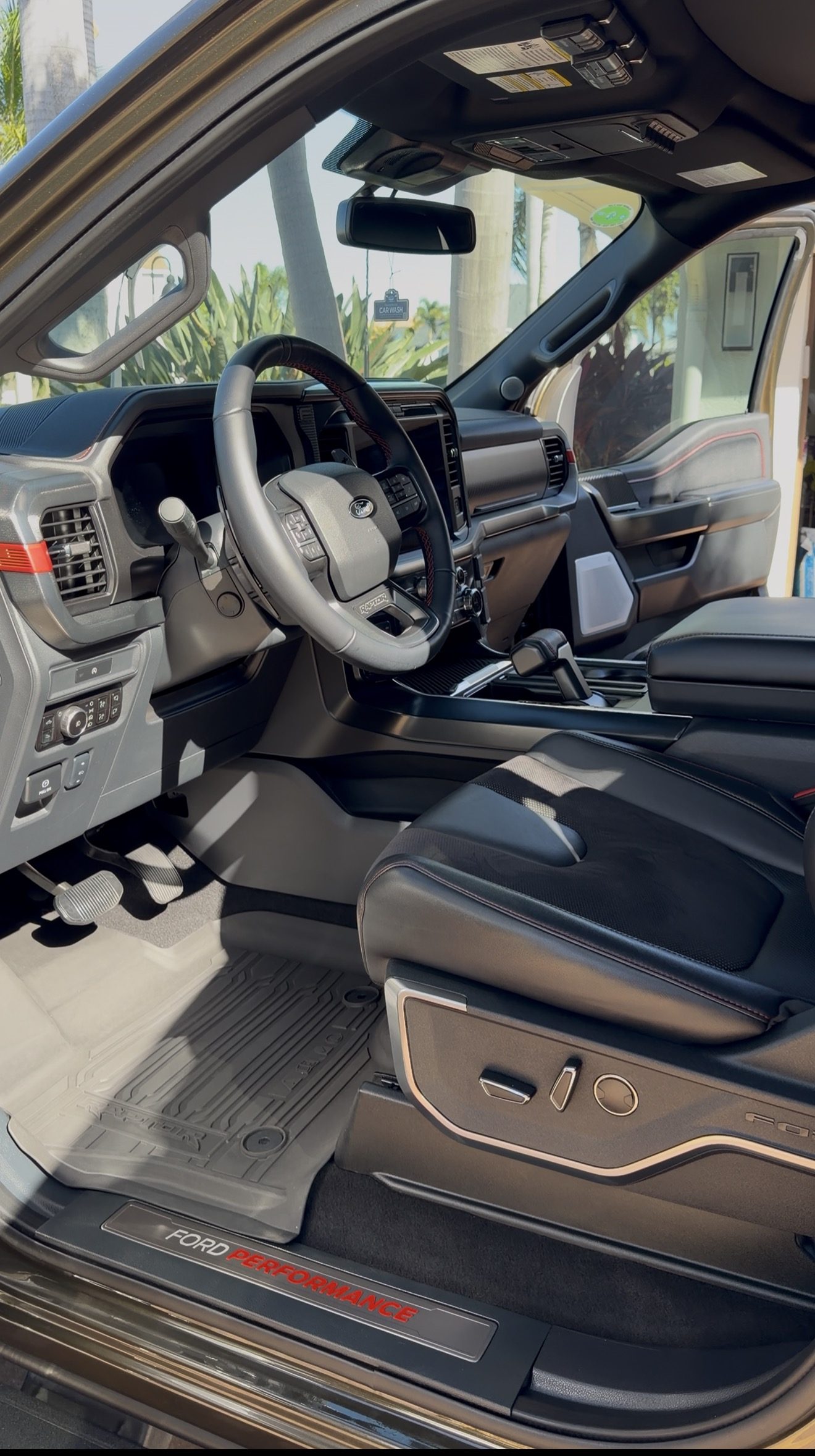 Clean, detailed cabin and floor mats of a Ford F-150 Raptor